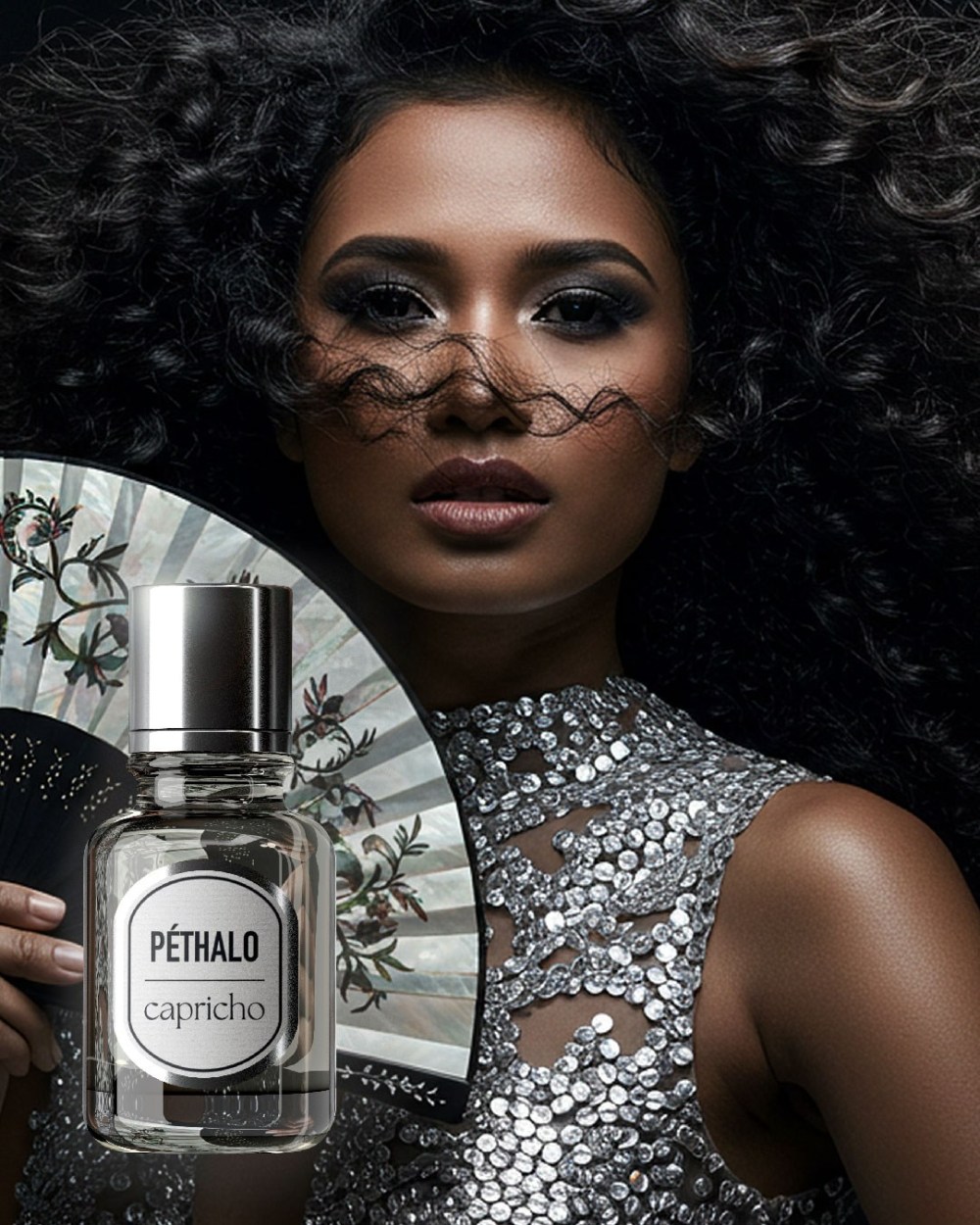 Image of a Péthalo perfume with a dark-skinned Filipina model in the background holding a fan and wearing a silver dress.